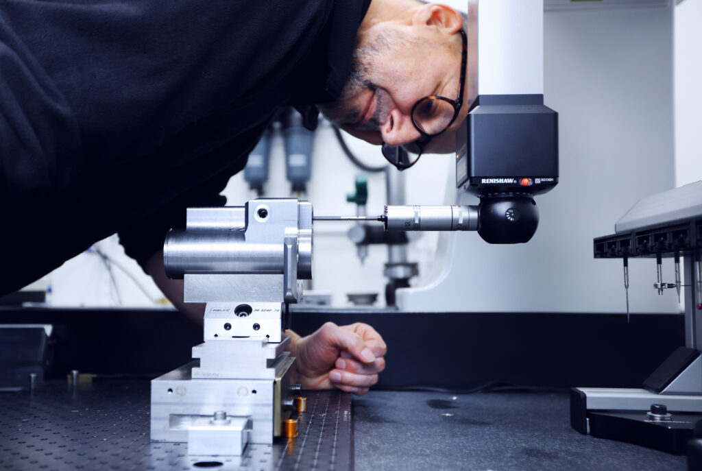 En koordinatmätmaskin från Mitutoyo med Renishaw-huvud, utrustad med scanningsfunktion. En släpande prob flyttas kontinuerligt medan den mäter. Mätingenjören Mikael Lissmatz sätter fast en färdig komponent som maskinen mäter enligt ett inställt program.